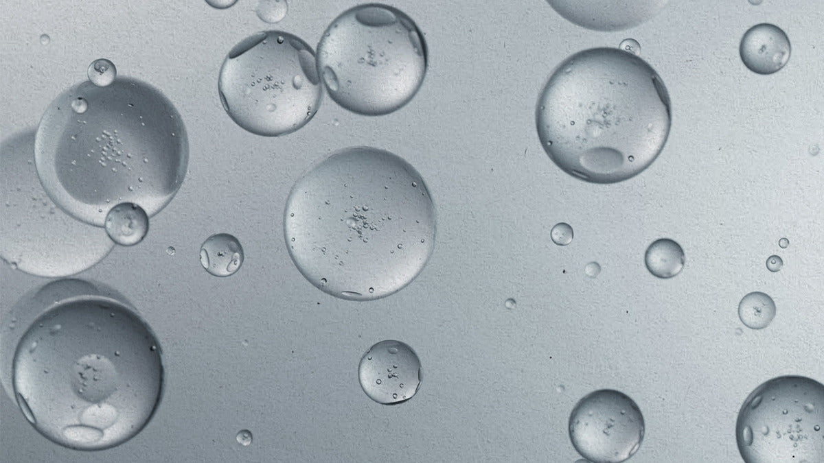 Close up of liquid droplets against grey background
