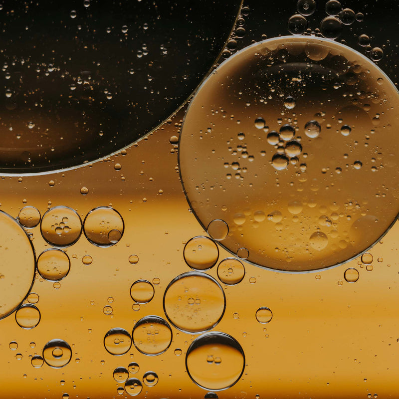 Close-up of oil and fatty acid droplets on a dark background