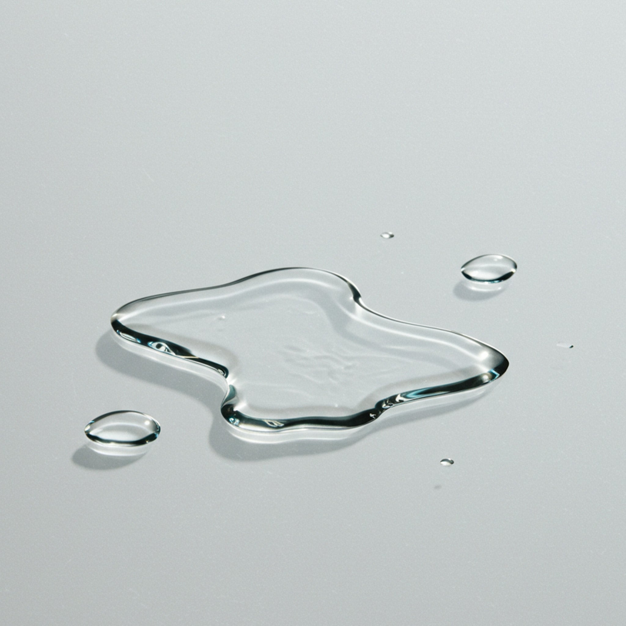 Close-up of droplets Levetem body exfoliating liquid exfoliator on a gray surface