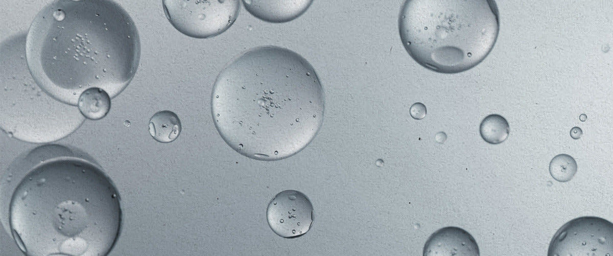 Close-up liquid droplets on a gray background
