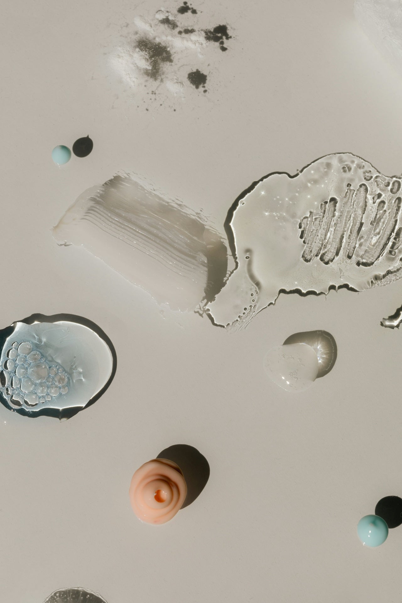 Various cosmetic product texture on a neutral background